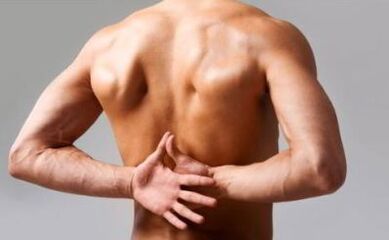 A man has back pain in the area under the shoulder blades